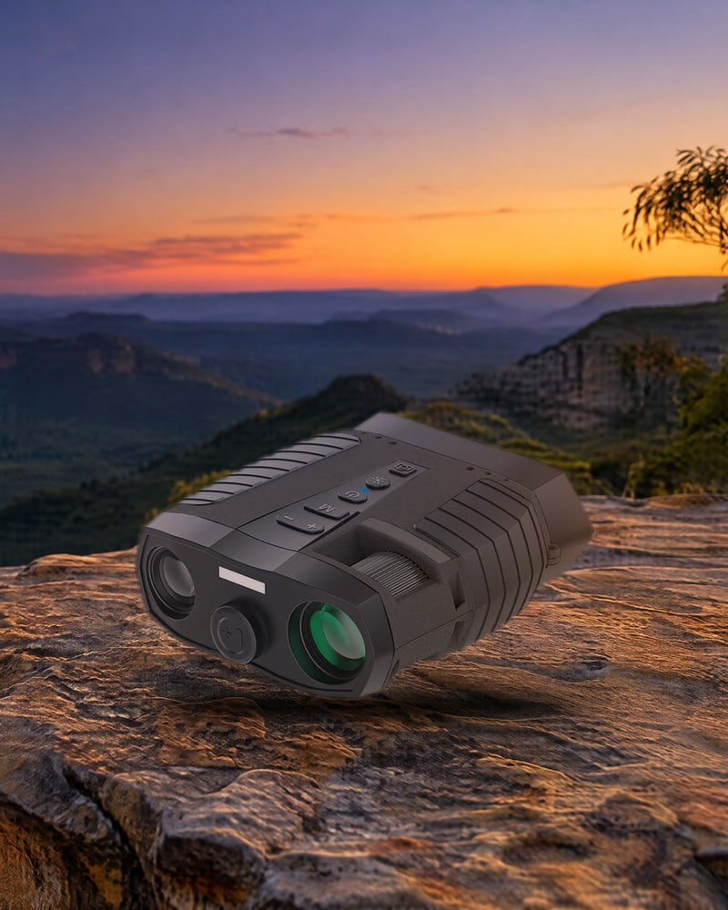 HD digital night vision binoculars resting on a sandstone ledge above a bush valley at dusk